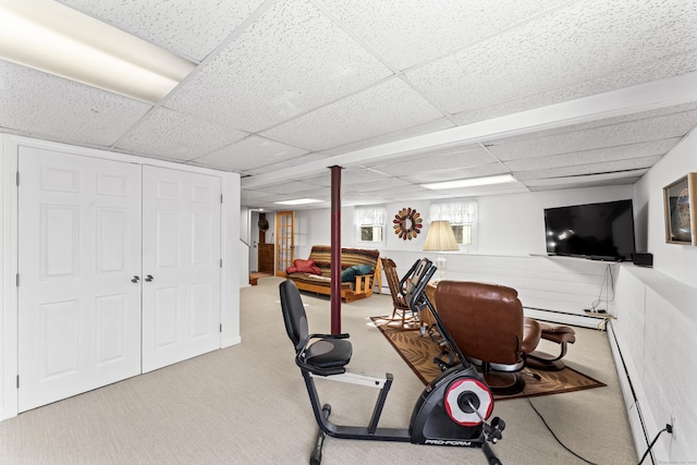 workout room featuring a drop ceiling, a baseboard radiator, carpet, and wainscoting