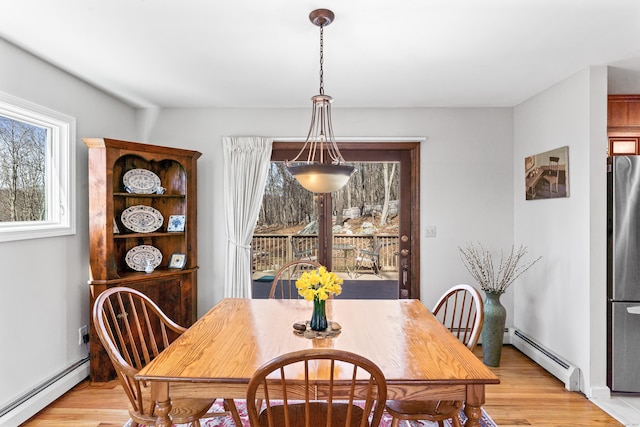 dining space with a baseboard radiator and light wood-style floors