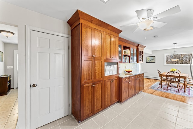 kitchen with hanging light fixtures, open shelves, light tile patterned floors, and brown cabinets