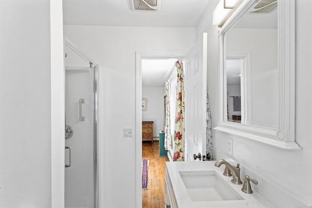 bathroom with a sink, visible vents, and wood finished floors