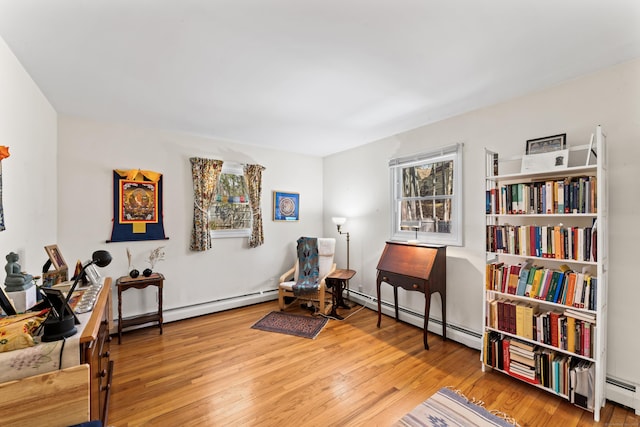 living area with wood finished floors and baseboard heating