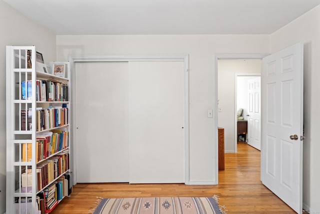 unfurnished bedroom with light wood finished floors and a closet