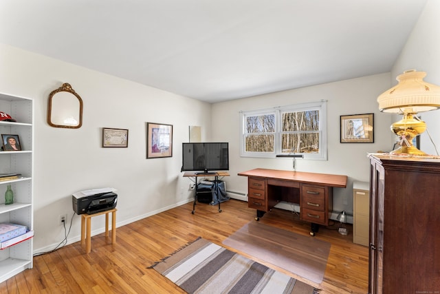 home office featuring light wood-type flooring, a baseboard radiator, and baseboards