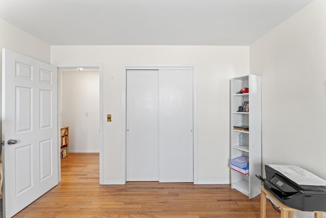 bedroom featuring a closet, baseboards, and light wood-style flooring