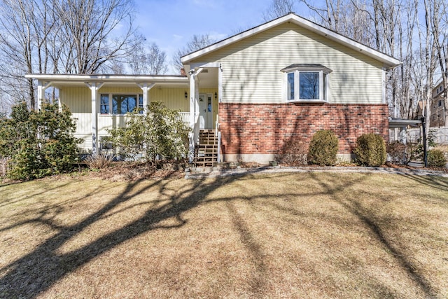 view of front of home featuring brick siding, a porch, and a front yard