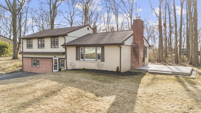 tri-level home featuring brick siding, roof with shingles, and a chimney