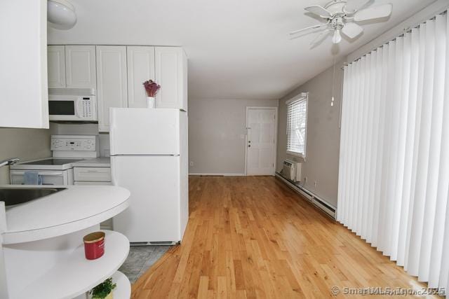 kitchen with a sink, white appliances, light wood finished floors, and white cabinetry