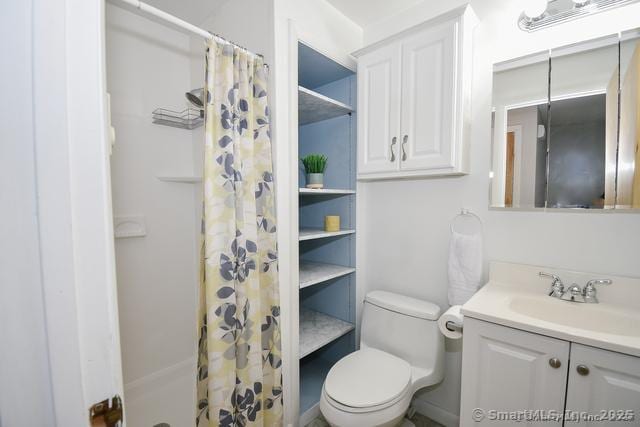 bathroom with a shower with shower curtain, toilet, and vanity