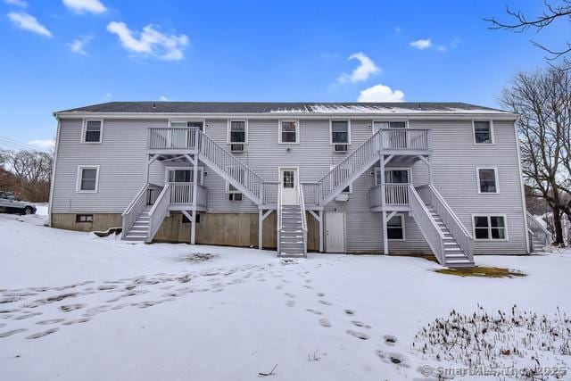 snow covered property with stairway