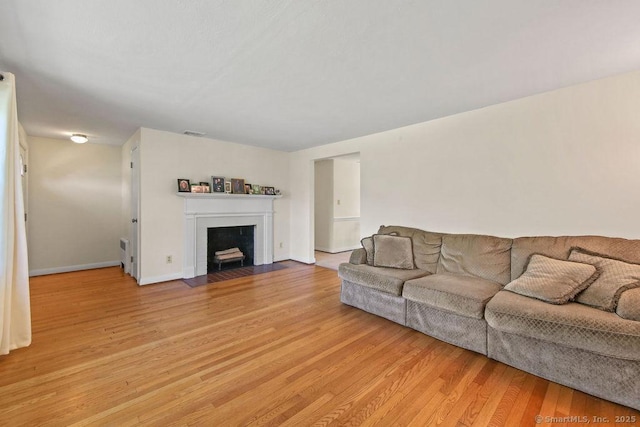 9 Waters Ave, Rocky Hill, CT 06067 - living area featuring a fireplace with flush hearth, light wood-style flooring, baseboards, and visible vents