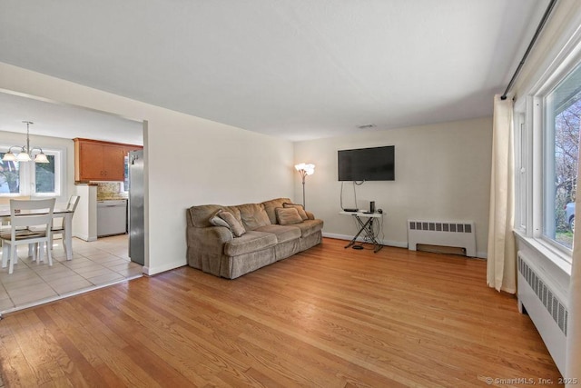 9 Waters Ave, Rocky Hill, CT 06067 - living room with a wealth of natural light, an inviting chandelier, light wood-style floors, and radiator