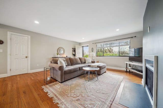 living area with recessed lighting, wood finished floors, and baseboards