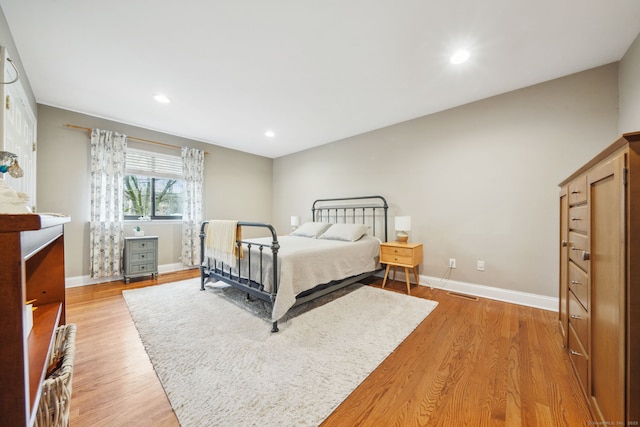 bedroom featuring light wood-style flooring, visible vents, and baseboards