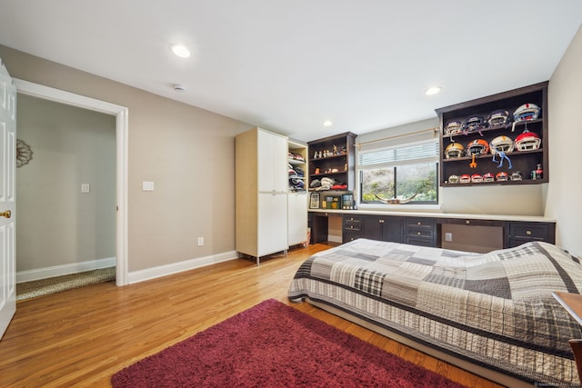 bedroom with light wood-type flooring, baseboards, built in desk, and recessed lighting