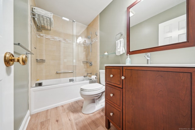 bathroom featuring toilet, combined bath / shower with glass door, wood finished floors, and vanity