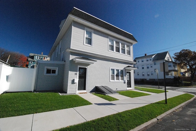 view of front facade featuring a front yard and fence