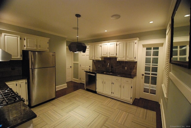 kitchen featuring pendant lighting, a sink, tasteful backsplash, stainless steel appliances, and white cabinets