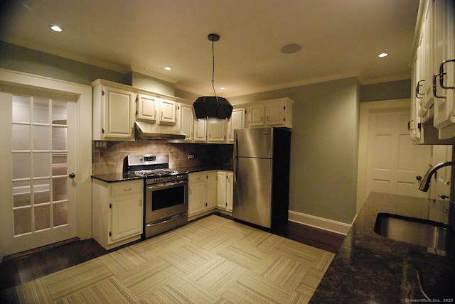 kitchen featuring under cabinet range hood, a sink, stainless steel appliances, white cabinets, and decorative backsplash