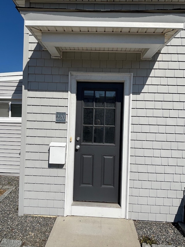 property entrance featuring roof with shingles