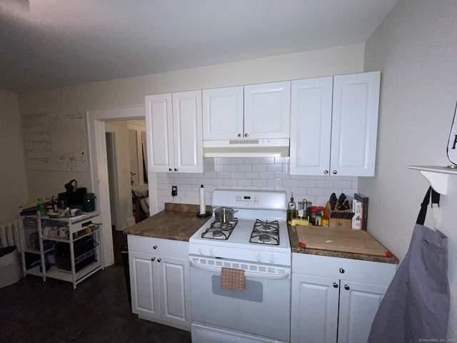 kitchen featuring under cabinet range hood, white cabinets, gas range gas stove, and backsplash