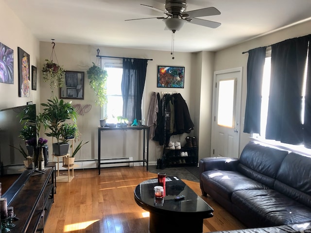 living room with a baseboard heating unit, a ceiling fan, and wood finished floors