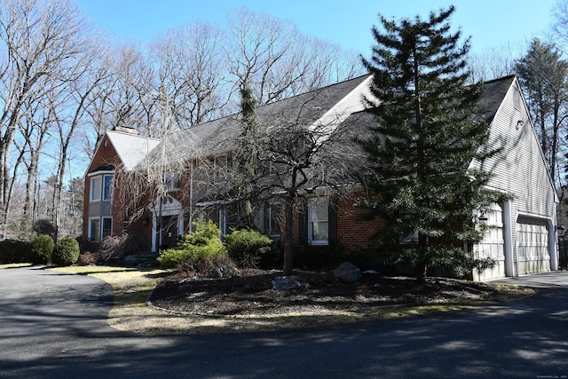 view of property exterior with an attached garage and driveway