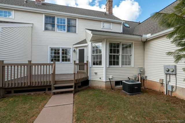 rear view of house with central air condition unit, a shingled roof, a chimney, and a wooden deck