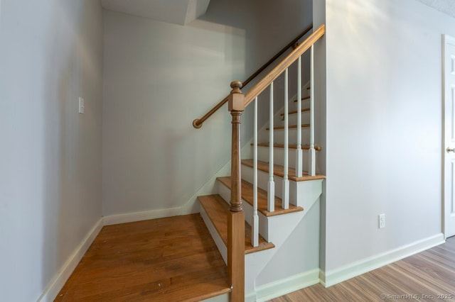 stairway featuring wood finished floors and baseboards