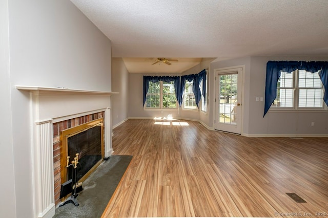 unfurnished living room featuring a fireplace, baseboards, and wood finished floors