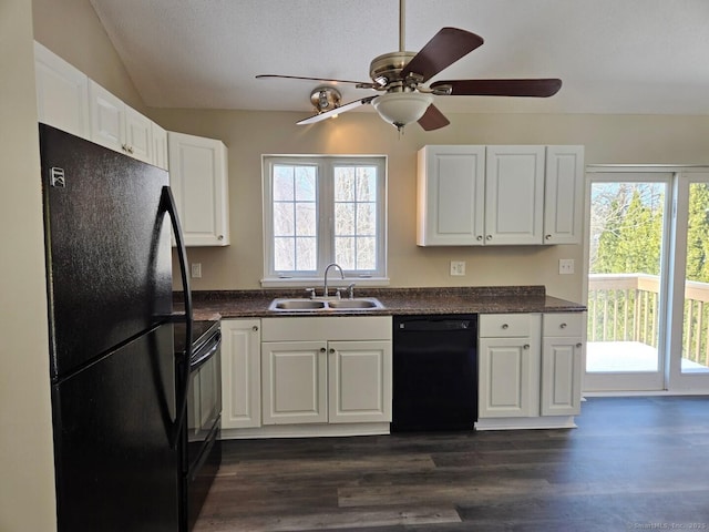 kitchen featuring black appliances, dark wood-style flooring, dark countertops, and a sink