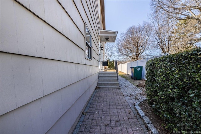 view of side of home featuring fence