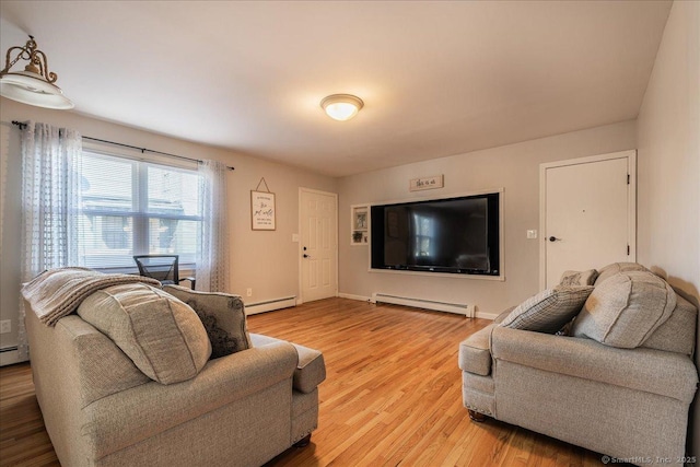 living area with a baseboard radiator, baseboards, and light wood-style floors