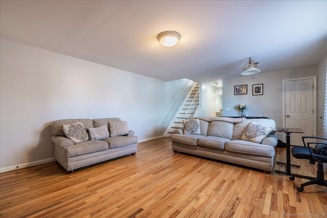 living room with stairs, wood finished floors, and baseboards