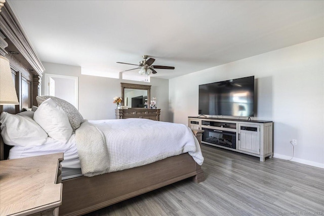 bedroom featuring wood finished floors, baseboards, and ceiling fan