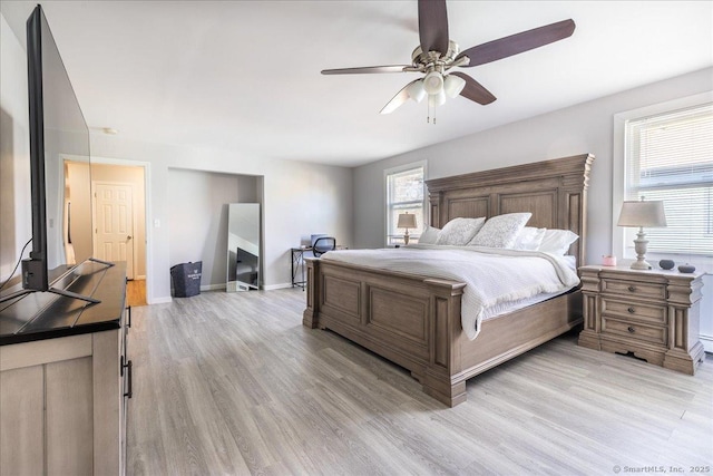 bedroom featuring baseboards, light wood-style floors, and a ceiling fan