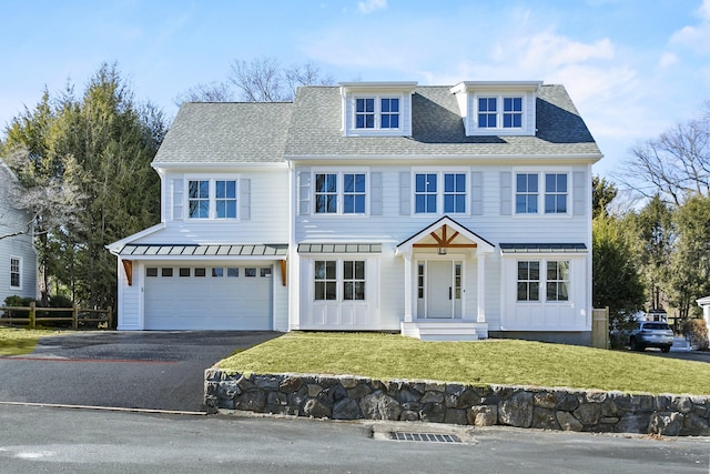 view of front of home with metal roof, a garage, driveway, roof with shingles, and a front yard