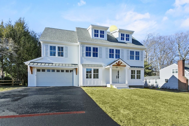 view of front of house featuring metal roof, aphalt driveway, roof with shingles, an attached garage, and a front lawn