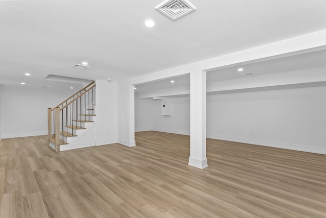 finished basement with recessed lighting, visible vents, stairway, and light wood finished floors