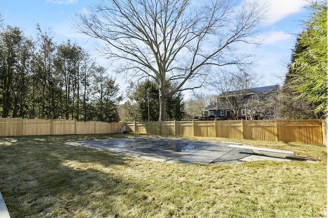 view of basketball court featuring a fenced backyard and a lawn