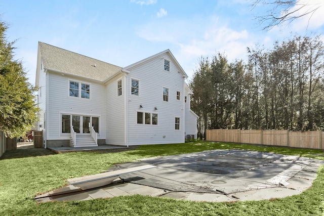 rear view of house featuring entry steps, a patio area, a yard, and a fenced backyard