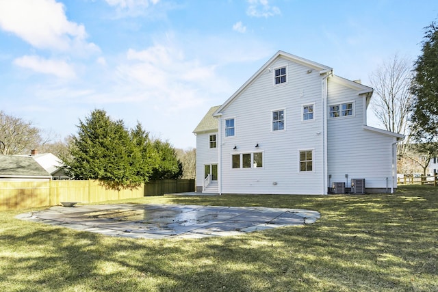 rear view of house featuring central air condition unit, a patio area, fence, and a yard