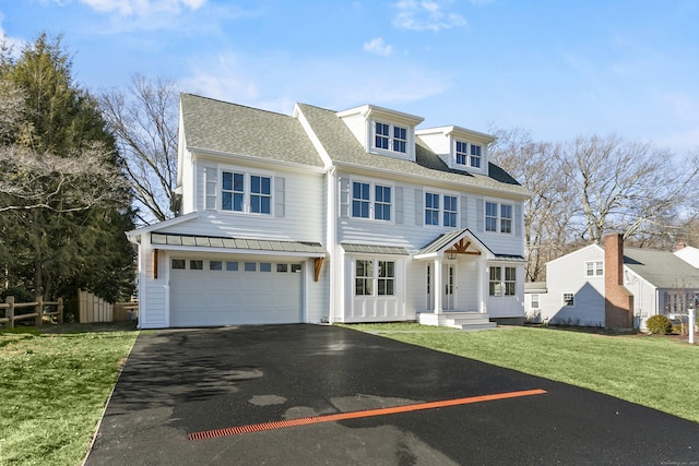 view of front of property featuring roof with shingles, fence, a garage, driveway, and a front lawn