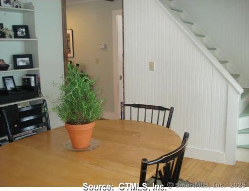 dining space featuring wood finished floors and stairs