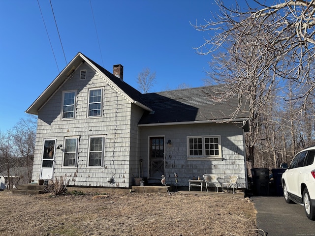 view of front of property featuring entry steps and a chimney