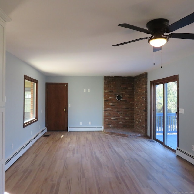 unfurnished living room with ceiling fan, baseboard heating, and wood finished floors