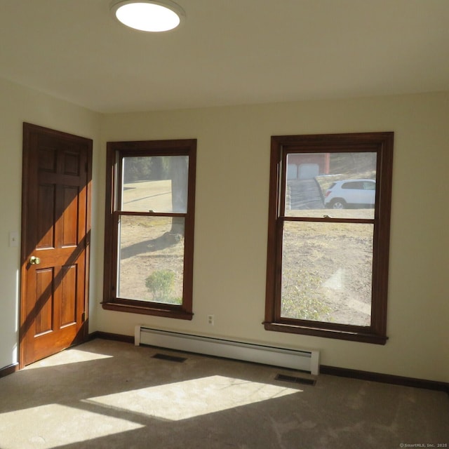 carpeted empty room with a wealth of natural light, baseboards, and baseboard heating