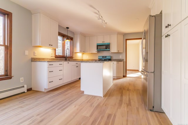 kitchen featuring white cabinets, light wood-style floors, appliances with stainless steel finishes, and a kitchen island