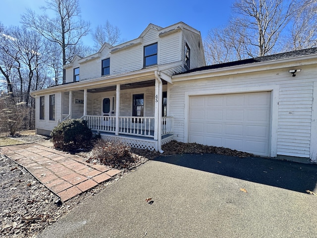 view of front facade featuring a garage, driveway, and a porch