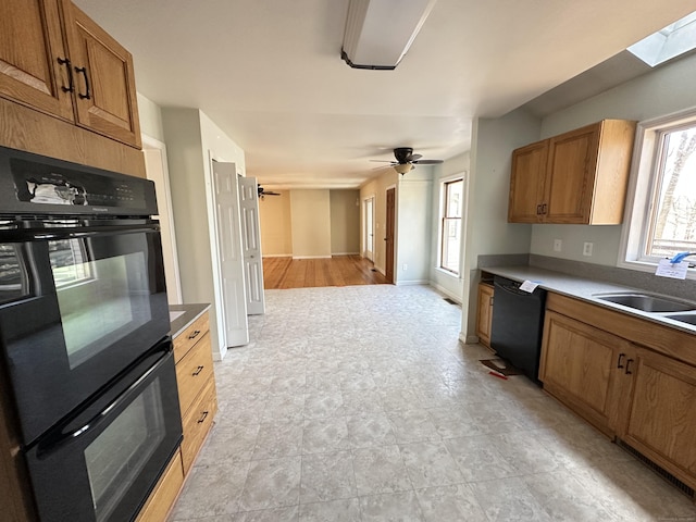 kitchen with black appliances, brown cabinetry, and a sink