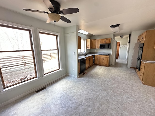 kitchen with visible vents, baseboards, light countertops, brown cabinets, and black appliances